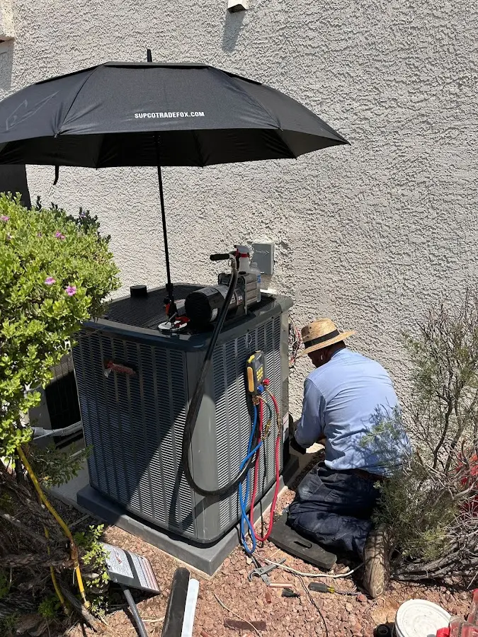 HVAC technician performing outdoor AC maintenance in Stockbridge